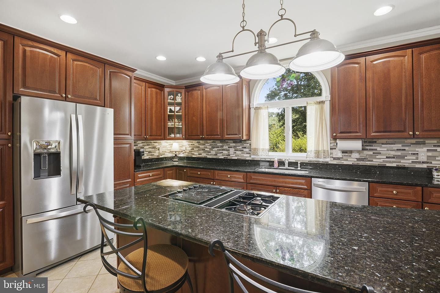 Kitchen with cherry cabinetry, granite island and gas cooktop