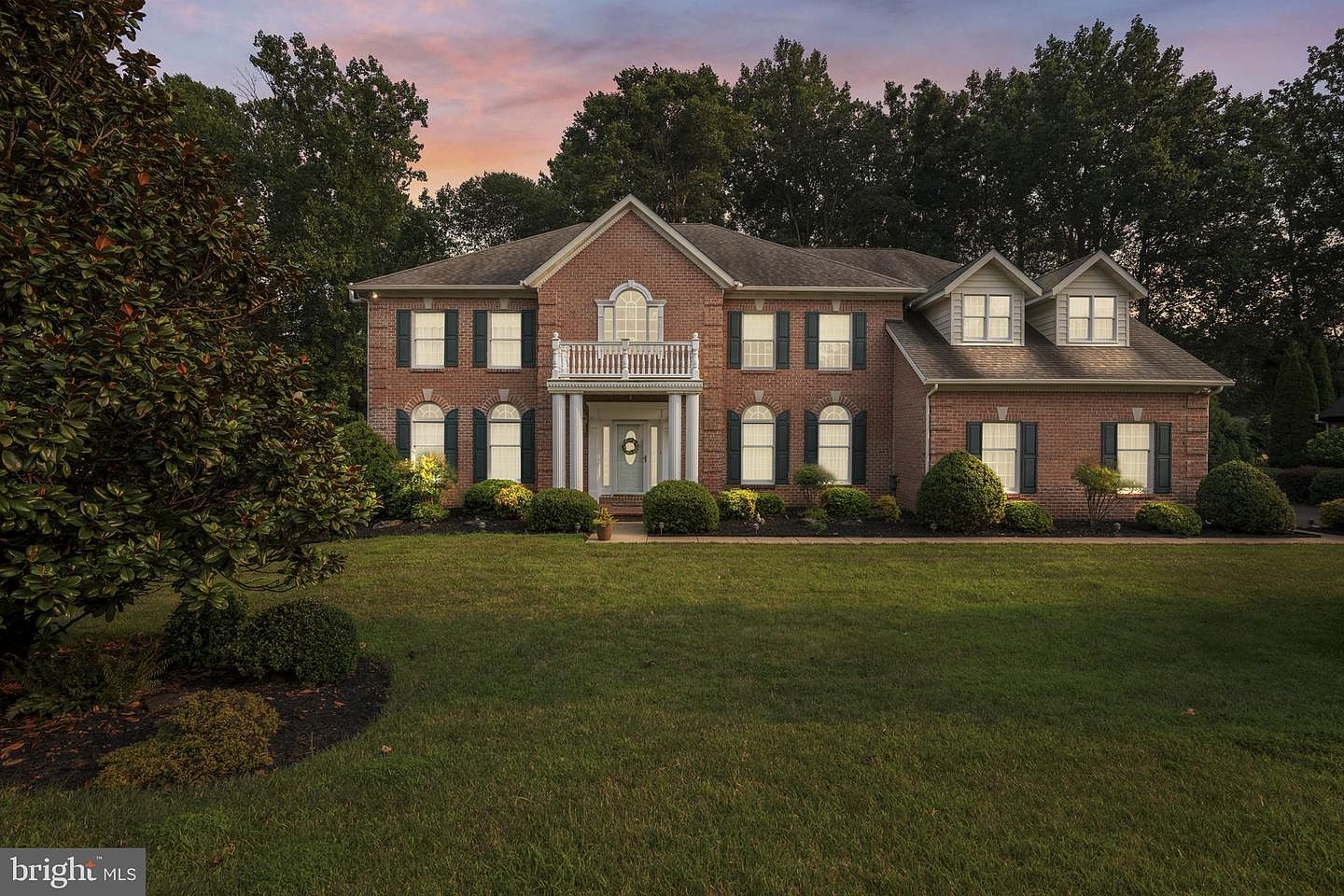Front elevation of the brick Colonial at 702 Glen Ct at dusk
