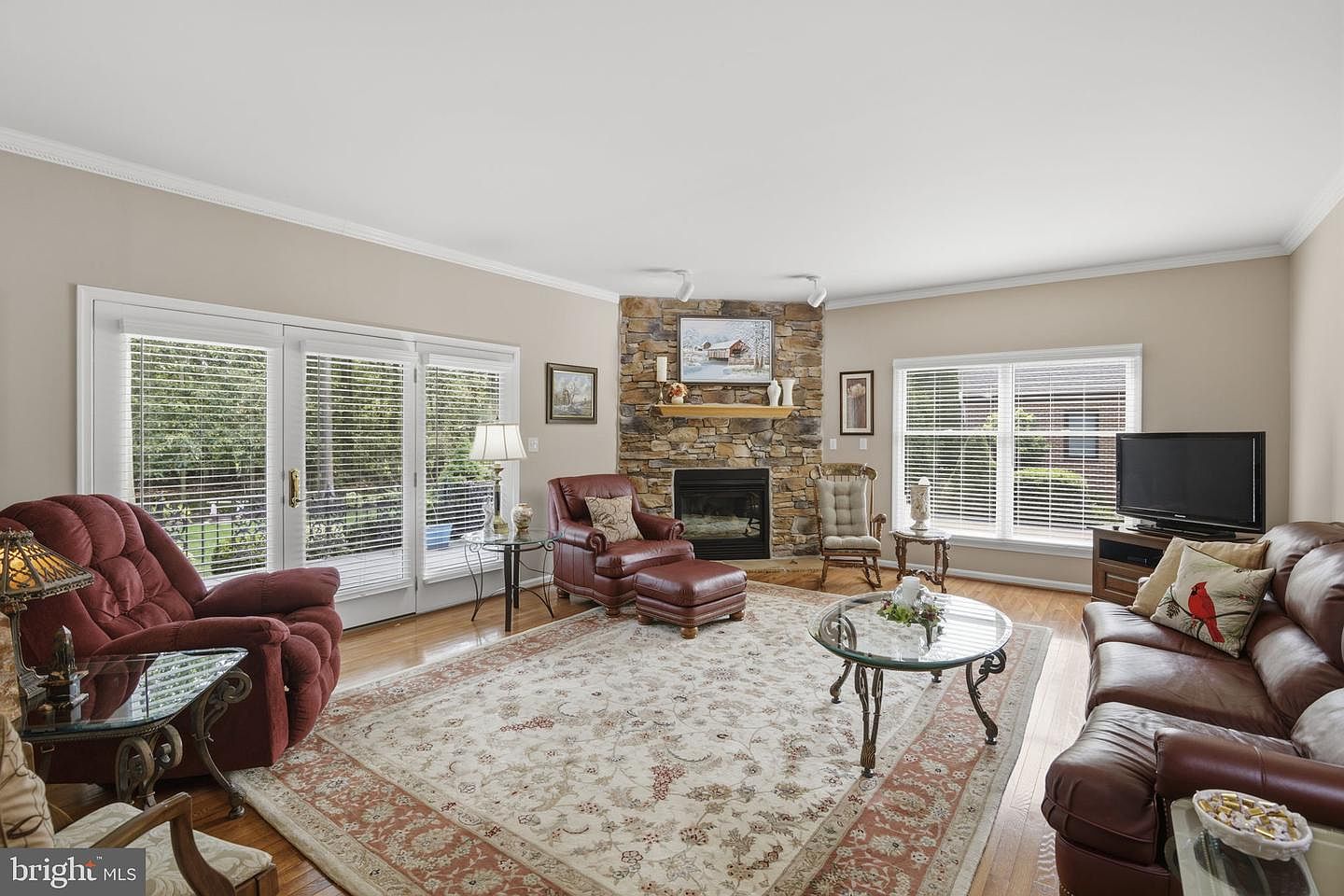 Family room with a floor-to-ceiling stone fireplace flanked by windows